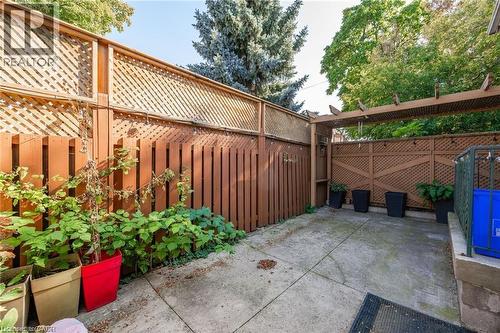Private outdoor space featuring concrete paving and perimeter fencing with lattice details - 252 Beechwood Avenue, Hamilton, ON - Outdoor