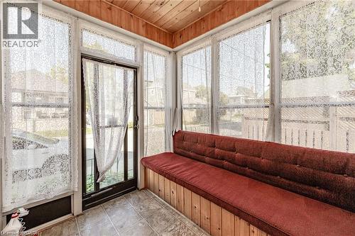 Sunroom featuring a wood-panel ceiling, tiled flooring, wood-finish wall paneling, and multiple large windows - 252 Beechwood Avenue, Hamilton, ON - Indoor Photo Showing Other Room