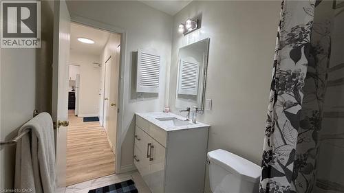 Bathroom featuring a vanity with a light-toned countertop, a rectangular mirror, and an overhead three-bulb light fixture - 206 Indian Road, Kitchener, ON - Indoor Photo Showing Bathroom