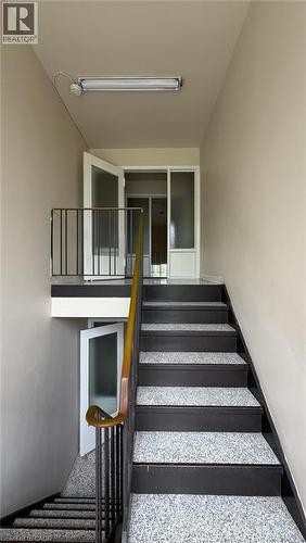 Multi-level staircase featuring speckled treads, dark risers, and a wooden handrail - 206 Indian Road, Kitchener, ON - Indoor Photo Showing Other Room