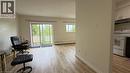 Living area featuring wood-finish flooring, light-colored walls, and a large sliding glass door - 206 Indian Road, Kitchener, ON  - Indoor 