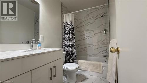 Bathroom featuring a white vanity with a light-toned countertop, a rectangular undermount sink with a chrome faucet, a wall-mounted mirror, and a white toilet - 206 Indian Road, Kitchener, ON - Indoor Photo Showing Bathroom