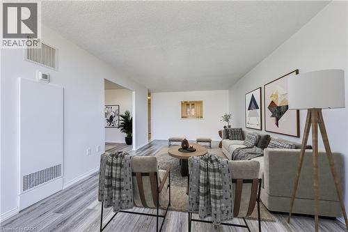 Open-concept living space featuring light wood-finish flooring, white walls, and a pass-through window - 1270 Maple Crossing Boulevard Unit# 1705, Burlington, ON - Indoor Photo Showing Dining Room