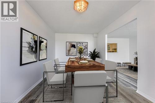 Dining area featuring wood-finish flooring, a contemporary ceiling fixture, and a pass-through window to an additional space - 1270 Maple Crossing Boulevard Unit# 1705, Burlington, ON - Indoor