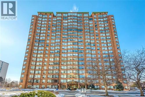Multi-story building featuring a brick facade with numerous windows - 1270 Maple Crossing Boulevard Unit# 1705, Burlington, ON - Outdoor With Facade