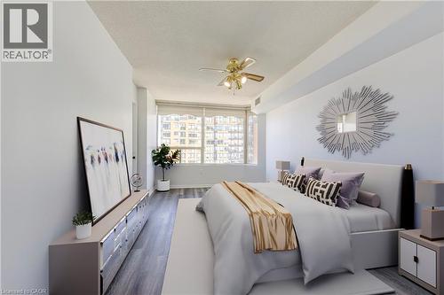 Spacious room featuring wood-finish flooring, a contemporary ceiling fan with integrated lighting, and expansive windows - 1270 Maple Crossing Boulevard Unit# 1705, Burlington, ON - Indoor Photo Showing Bedroom