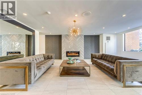 Spacious common area featuring light-toned tile flooring, recessed ceiling lighting, and a contemporary chandelier - 1270 Maple Crossing Boulevard Unit# 1705, Burlington, ON - Indoor With Fireplace