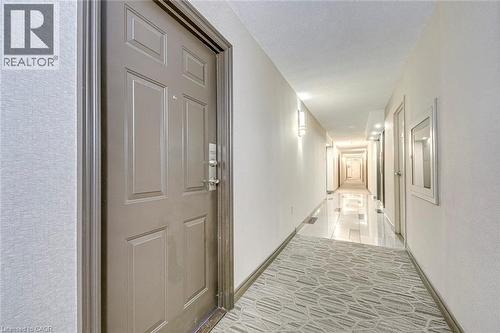 Entry door with panel detailing and polished chrome hardware - 1270 Maple Crossing Boulevard Unit# 1705, Burlington, ON - Indoor Photo Showing Other Room