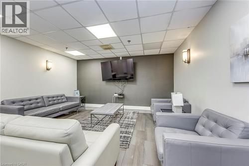 Spacious lounge area featuring neutral wall tones and a distinct accent wall - 1270 Maple Crossing Boulevard Unit# 1705, Burlington, ON - Indoor Photo Showing Other Room