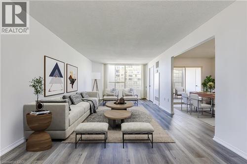 Spacious living area featuring wood-finish flooring, light-toned walls, and abundant natural light from large windows - 1270 Maple Crossing Boulevard Unit# 1705, Burlington, ON - Indoor Photo Showing Living Room
