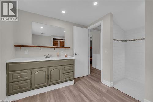 Bathroom featuring a vanity with a white countertop and sage green cabinetry, a recessed sink, and a wall-mounted mirror - 270 Erie Boulevard, Long Point, ON - Indoor