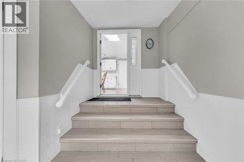Entryway featuring light-toned tile flooring on stairs, white wainscoting, and neutral wall paint - 270 Erie Boulevard, Long Point, ON - Indoor Photo Showing Other Room
