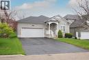Light gray brick exterior featuring a covered front porch with white railings, an arched window, and an oversized two-car garage. - 565 Springwater Drive, Waterloo, ON  - Outdoor With Facade 