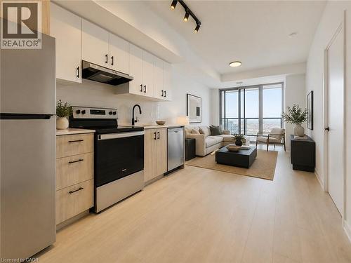 Open-concept living space featuring light wood-finish flooring - 4878 Powers Common Unit# C-1108, Burlington, ON - Indoor Photo Showing Kitchen With Stainless Steel Kitchen