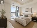 Light wood-finish flooring complements the neutral wall tones - 4878 Powers Common Unit# C-1108, Burlington, ON  - Indoor Photo Showing Bedroom 