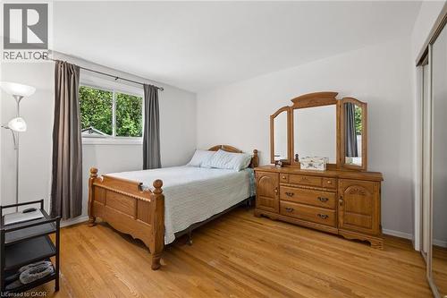 Bright room featuring wood-finish flooring and a window with exterior green foliage - 1862 Briarwood Drive, Cambridge, ON - Indoor Photo Showing Bedroom