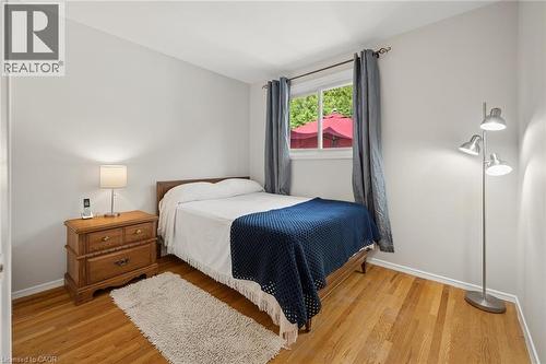 Bright bedroom featuring light-toned walls, wood-finish flooring, and a window with a green outdoor backdrop - 1862 Briarwood Drive, Cambridge, ON - Indoor Photo Showing Bedroom