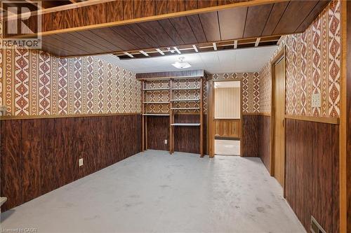 Room featuring wood-finish paneling, patterned wallpaper, and light-toned flooring - 1862 Briarwood Drive, Cambridge, ON - Indoor