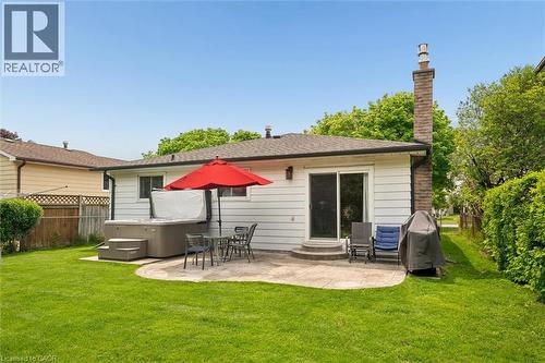 Expansive rear yard featuring a hot tub, a curved concrete patio, and a sliding glass door entry to the home - 1862 Briarwood Drive, Cambridge, ON - Outdoor With Deck Patio Veranda