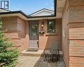 Brick exterior with a paved walkway, covered entry, front door with transom window, exterior lighting, and a single window with dark trim - 1862 Briarwood Drive, Cambridge, ON  - Outdoor With Exterior 