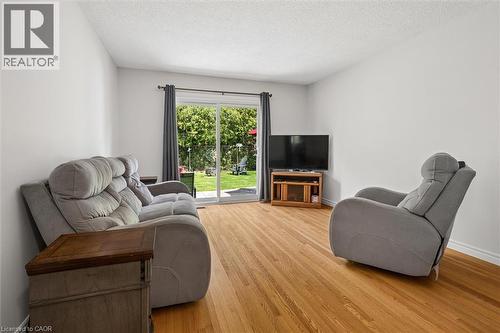 Hardwood flooring throughout a room with white walls and a sliding glass door - 1862 Briarwood Drive, Cambridge, ON - Indoor Photo Showing Living Room