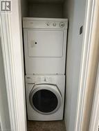 Dedicated laundry closet featuring a stacked washer and dryer unit - 
