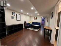 Open-concept living area featuring rich wood-finish flooring, recessed lighting, and neutral wall tones - 
