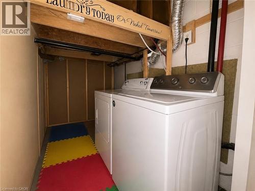 Dedicated laundry area featuring white top-load appliances, exposed wood beams, and a finished wall - 917 Orpha Street, Burlington, ON - Indoor Photo Showing Laundry Room