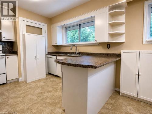 Kitchen featuring white cabinetry, a brown speckled countertop, and light-toned tile flooring - 917 Orpha Street, Burlington, ON - Indoor Photo Showing Kitchen With Double Sink