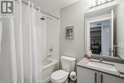 Contemporary bathroom featuring a white bathtub with subway tile surround and a rain shower head - 