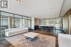 Spacious common area featuring recessed lighting, extensive glass partitions, and dark tile flooring - 