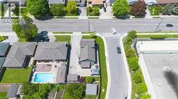 Expansive backyard featuring an in-ground swimming pool, a multi-level wood deck, and a paved patio area - 