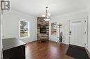 Entryway featuring a corner stone fireplace with a wood mantle, rich wood-finish flooring, and crown molding - 69 Nash Road S, Hamilton, ON  - Indoor With Fireplace 