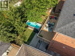 Expansive outdoor living area featuring a cedar deck with railing, a ground-level patio, and a swim spa - 