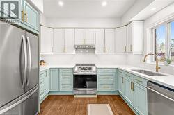 Contemporary kitchen featuring QUARTZ COUNTER TOPS & BACKSPLASH, stainless steel appliances, and wood-finish flooring - 