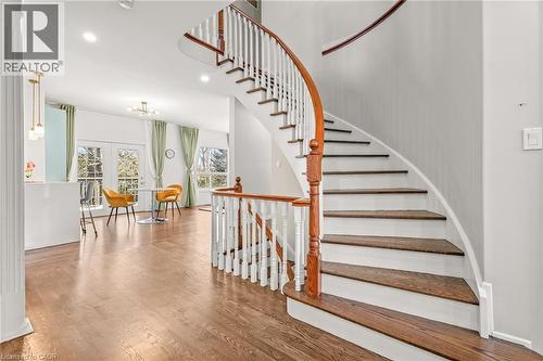 Curved staircase featuring wood-finish treads and white risers, complemented by a wood-finish handrail and white balusters - 12 Buman Court, Barrie, ON - Indoor Photo Showing Other Room