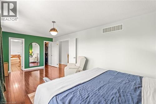 Hardwood-finish flooring throughout, complemented by a statement green accent wall - 12 Buman Court, Barrie, ON - Indoor Photo Showing Bedroom
