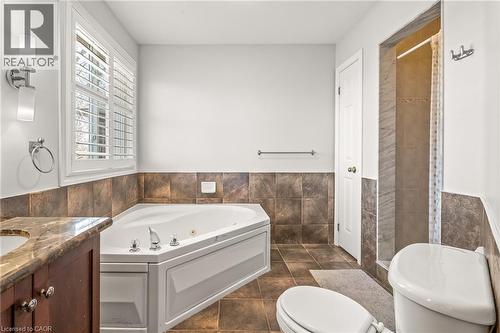 Corner soaking tub with polished chrome fixtures and white plantation shutters - 12 Buman Court, Barrie, ON - Indoor Photo Showing Bathroom