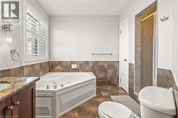 Corner soaking tub with polished chrome fixtures and white plantation shutters - 