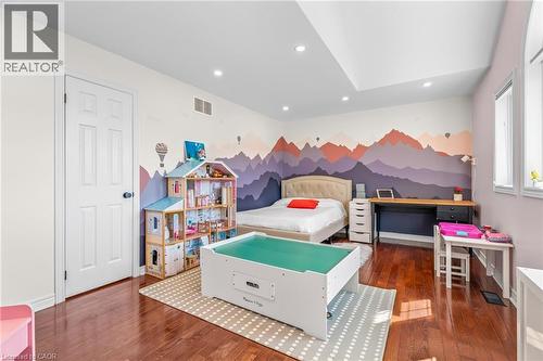 Spacious room with a walk-in closet featuring wood-finish flooring, a tray ceiling with recessed lighting, and multiple windows providing abundant natural light. - 12 Buman Court, Barrie, ON - Indoor