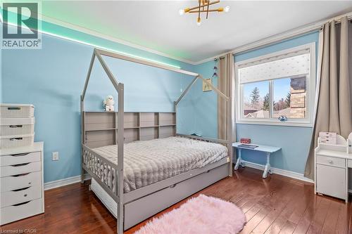 Hardwood flooring and light blue walls featured in a bedroom with a large window and crown molding - 12 Buman Court, Barrie, ON - Indoor Photo Showing Bedroom