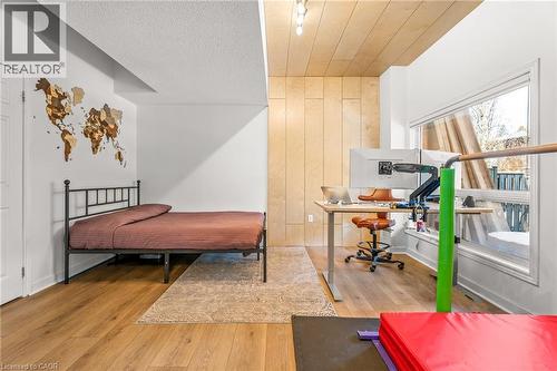 Versatile room featuring Luxury Vinyl Plank flooring and a wood paneled accent wall - 12 Buman Court, Barrie, ON - Indoor