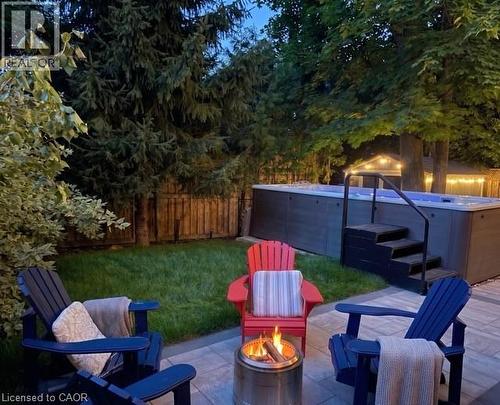 Private backyard oasis featuring a swim spa with integrated steps and handrail, surrounded by lush mature trees and a manicured lawn - 12 Buman Court, Barrie, ON - Outdoor With Deck Patio Veranda With Backyard