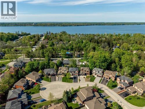 Aerial perspective showcasing a residential cul-de-sac with diverse architectural styles, framed by mature trees and a distant body of water - 12 Buman Court, Barrie, ON - Outdoor With Body Of Water With View