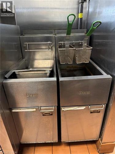 Stainless steel commercial fryers with integrated baskets and a stainless steel backsplash - 255 King Street N, Waterloo, ON 