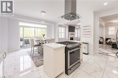 Contemporary kitchen featuring stainless steel appliances, white cabinetry, and large format marble-look tile flooring - 9 Fleming Crescent, Caledonia, ON - Indoor Photo Showing Other Room