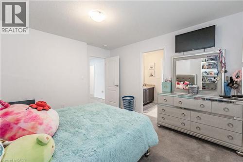 Carpeted bedroom featuring a flush-mount ceiling light and a dresser with mirror - 9 Fleming Crescent, Caledonia, ON - Indoor Photo Showing Bedroom