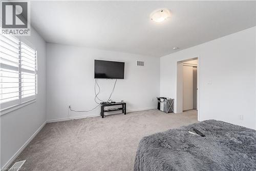 Carpeted room featuring white walls, window with white plantation shutters, and a ceiling-mounted light fixture - 9 Fleming Crescent, Caledonia, ON - Indoor Photo Showing Bedroom