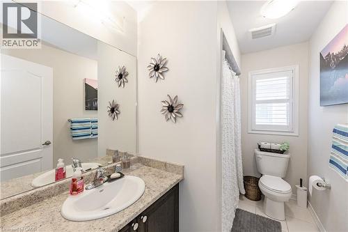Bathroom featuring a dark wood-finish vanity with a light-colored countertop, an undermount sink, and a large wall-mounted mirror - 9 Fleming Crescent, Caledonia, ON - Indoor Photo Showing Bathroom