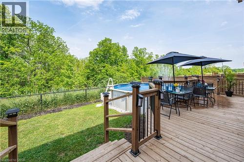 Expansive wood-finish deck featuring a built-in above-ground pool and surrounding black metal fencing - 9 Fleming Crescent, Caledonia, ON - Outdoor With Deck Patio Veranda